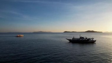 Filipinler 'in Linapacan şehrinde günbatımında geleneksel Filipinli tekne bangka. Turuncu gökyüzü günbatımı cennet kumsalı.