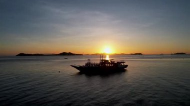 Filipinler 'in Linapacan şehrinde günbatımında geleneksel Filipinli tekne bangka. Turuncu gökyüzü günbatımı cennet kumsalı.