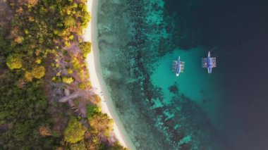 Filipinler 'in Linapacan şehrinde günbatımında geleneksel Filipinli tekne bangka. Turuncu gökyüzü günbatımı cennet kumsalı.