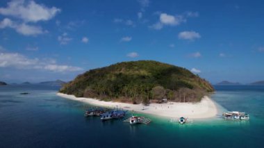 Filipinler, Palawan 'da beyaz kumlu ve kristal berrak suyu olan Cagdanao adasının 4K Hava Aracı videosu