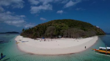 Filipinler, Palawan 'da beyaz kumlu ve kristal berrak suyu olan Cagdanao adasının 4K Hava Aracı videosu