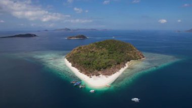 Filipinler, Palawan 'da beyaz kumlu ve kristal berrak suyu olan Cagdanao adasının 4K Hava Aracı videosu