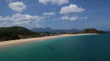 Linapacan, Palawan, Filipinler 'de güzel kum ve palmiye ağaçları olan ikiz kumsalı ve Nacpan plajının 4K Hava Aracı videosu