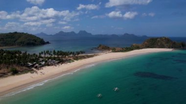 Linapacan, Palawan, Filipinler 'de güzel kum ve palmiye ağaçları olan ikiz kumsalı ve Nacpan plajının 4K Hava Aracı videosu