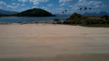 Linapacan, Palawan, Filipinler 'de güzel kum ve palmiye ağaçları olan ikiz kumsalı ve Nacpan plajının 4K Hava Aracı videosu