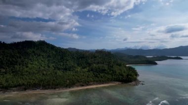 Güneşli bir günde, arkasında bulutlar olan büyülü palmiye ağaçları ve kristal mavi sularla güzel Coconut plajının 4K Hava Aracı videosu. Port Barton, Palawan Filipinleri