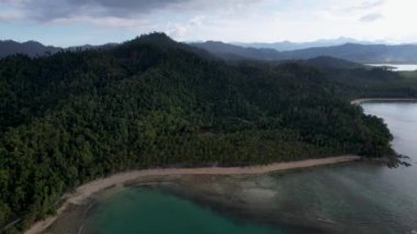 Güneşli bir günde, arkasında bulutlar olan büyülü palmiye ağaçları ve kristal mavi sularla güzel Coconut plajının 4K Hava Aracı videosu. Port Barton, Palawan Filipinleri