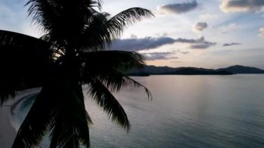 Gün batımında harika palmiye ağaçları ve kristal berrak mavi suyu olan güzel White Beach 'in 4K Hava Aracı videosu. Barton Limanı, Filipinler