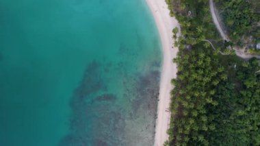 Gün batımında harika palmiye ağaçları ve kristal berrak mavi suyu olan güzel White Beach 'in 4K Hava Aracı videosu. Barton Limanı, Filipinler