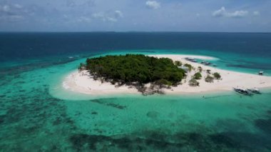 Patawan Adası 'nın güzel beyaz kumlu ve turkuaz mavi sulu 4K Hava Aracı videosu. Sahile demirlemiş kayıklar ve ortasında palmiye ağaçları. Balabac, Filipinler