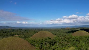 Filipinler 'in Bohol Adası' ndaki Chocolate Hills 'te doğanın güzelliği ile ilgili 4K hava aracı videosu. Bu isim, kurak mevsimde tepeleri kaplayan ve kahverengileşen çimlerden geliyor.
