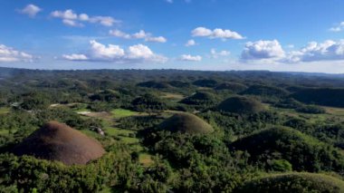 Filipinler 'in Bohol Adası' ndaki Chocolate Hills 'te doğanın güzelliği ile ilgili 4K hava aracı videosu. Bu isim, kurak mevsimde tepeleri kaplayan ve kahverengileşen çimlerden geliyor.