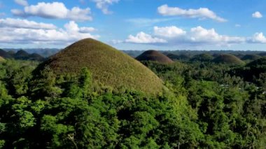 Filipinler 'in Bohol Adası' ndaki Chocolate Hills 'te doğanın güzelliği ile ilgili 4K hava aracı videosu. Bu isim, kurak mevsimde tepeleri kaplayan ve kahverengileşen çimlerden geliyor.