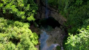 Filipinler 'deki Bohol Adası' nın derin yeşil ormanlarında gizli Kawasan Şelalesinin 4K Hava Aracı videosu.