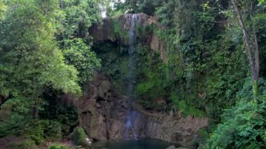 Filipinler 'deki Bohol Adası' nın derin yeşil ormanlarında gizli Kawasan Şelalesinin 4K Hava Aracı videosu.