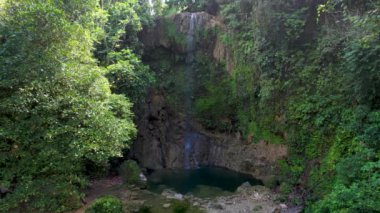 Filipinler 'deki Bohol Adası' nın derin yeşil ormanlarında gizli Kawasan Şelalesinin 4K Hava Aracı videosu.