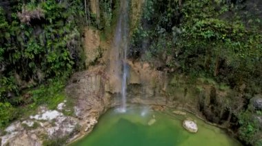 Filipinler, Bohol 'da kristal yeşil su ve sık ormanlı tenha Camugao Şelaleleri' nin 4K Hava Aracı videosu.
