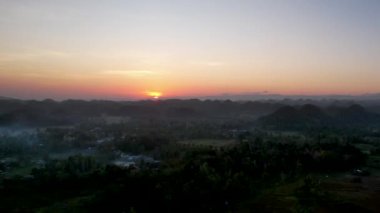 4K Hava Aracı, Bohol, Filipinler 'de eşsiz bir jeolojik oluşum olan Chocolate Hills' in üzerinde büyülü bir güneşin doğuşunu gösteren altın saat videosu.