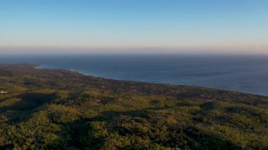 Siquijor adasının altın saatindeki 4K Hava Aracı videosu. Filipinler, Filipinler 'e bakan yemyeşil orman ve palmiye ağaçları.