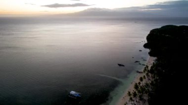 4K Hava Aracı, Filipinler 'deki Siquijor Adası' nda gün batımını izleyen insanların altın saatinde Paliton plajında güzel bir günbatımı görüntüsü.