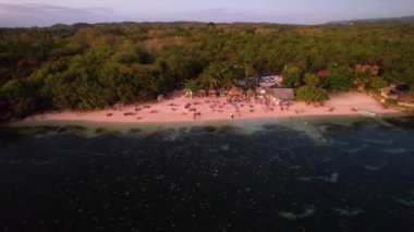 4K Hava Aracı, Filipinler 'deki Siquijor Adası' nda gün batımını izleyen insanların altın saatinde Paliton plajında güzel bir günbatımı görüntüsü.