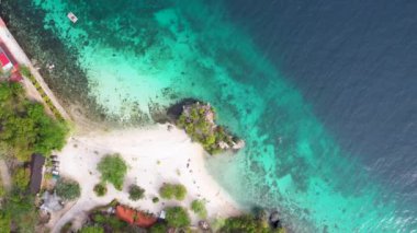 Filipinler 'in Siquijor adasındaki Salagdoong sahilindeki berrak turkuaz sudaki meşhur platform sıçrama noktasının 4K Hava Aracı videosu