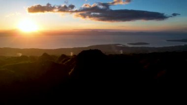 4K Hava Aracı, güzel Kumarhane Tepesi üzerinde büyüleyici bir günbatımı görüntüsü kıyı şeridi manzarası ve etrafındaki sıradağlar ve rüzgarda bir bayrak, Cebu, Filipinler