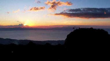 4K Hava Aracı, güzel Kumarhane Tepesi üzerinde büyüleyici bir günbatımı görüntüsü kıyı şeridi manzarası ve etrafındaki sıradağlar ve rüzgarda bir bayrak, Cebu, Filipinler