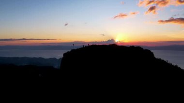 4K Hava Aracı, güzel Kumarhane Tepesi üzerinde büyüleyici bir günbatımı görüntüsü kıyı şeridi manzarası ve etrafındaki sıradağlar ve rüzgarda bir bayrak, Cebu, Filipinler