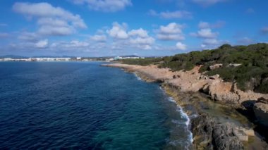 4K Hava Aracı 'nın Mallorca' da kristal berrak suyla çekilmiş videosu güneşli bir yaz gününde sert dalgalar kayalıklara çarpıyor.