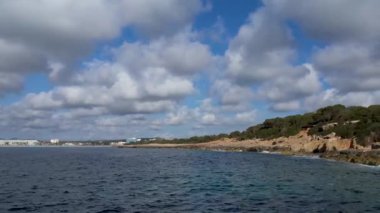 4K Hava Aracı 'nın Mallorca' da kristal berrak suyla çekilmiş videosu güneşli bir yaz gününde sert dalgalar kayalıklara çarpıyor.