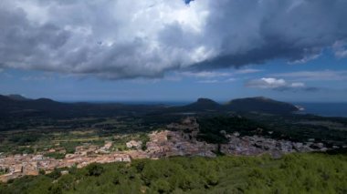 4K Hava Aracı, güneşli bir yaz gününde dağlarla ve denizlerle çevrili tepede devasa bir kalesi olan güzel bir terracotta renkli kasabasının videosu, Capdepera, Mallorca