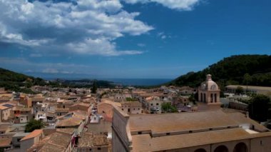 4K Hava Aracı, güneşli bir yaz gününde dağlarla ve denizlerle çevrili tepede devasa bir kalesi olan güzel bir terracotta renkli kasabasının videosu, Capdepera, Mallorca