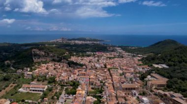 4K Hava Aracı, güneşli bir yaz gününde dağlarla ve denizlerle çevrili tepede devasa bir kalesi olan güzel bir terracotta renkli kasabasının videosu, Capdepera, Mallorca