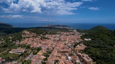 4K Hava Aracı, güneşli bir yaz gününde dağlarla ve denizlerle çevrili tepede devasa bir kalesi olan güzel bir terracotta renkli kasabasının videosu, Capdepera, Mallorca