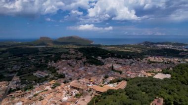 4K Hava Aracı, güneşli bir yaz gününde dağlarla ve denizlerle çevrili tepede devasa bir kalesi olan güzel bir terracotta renkli kasabasının videosu, Capdepera, Mallorca
