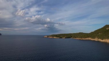 4K Hava Aracı, İspanya 'nın Mallorca adasındaki Mirador Badia de Pollenca adasında ikonik bir gemi ve uçurumlarla büyüleyici bir günbatımı videosu.