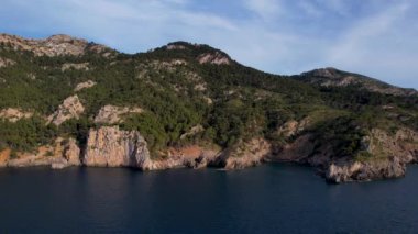 4K Hava Aracı, İspanya 'nın Mallorca adasındaki Mirador Badia de Pollenca adasında ikonik bir gemi ve uçurumlarla büyüleyici bir günbatımı videosu.