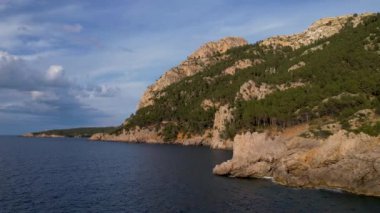 4K Hava Aracı, İspanya 'nın Mallorca adasındaki Mirador Badia de Pollenca adasında ikonik bir gemi ve uçurumlarla büyüleyici bir günbatımı videosu.
