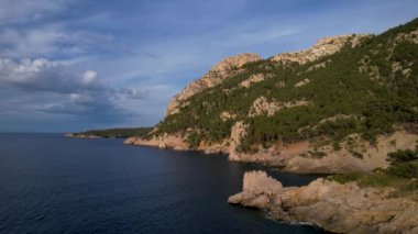 4K Hava Aracı, İspanya 'nın Mallorca adasındaki Mirador Badia de Pollenca adasında ikonik bir gemi ve uçurumlarla büyüleyici bir günbatımı videosu.