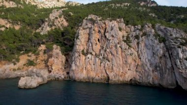 4K Hava Aracı, İspanya 'nın Mallorca adasındaki Mirador Badia de Pollenca adasında ikonik bir gemi ve uçurumlarla büyüleyici bir günbatımı videosu.