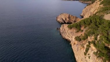 4K Hava Aracı, İspanya 'nın Mallorca adasındaki Mirador Badia de Pollenca adasında ikonik bir gemi ve uçurumlarla büyüleyici bir günbatımı videosu.