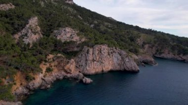 4K Hava Aracı, İspanya 'nın Mallorca adasındaki Mirador Badia de Pollenca adasında ikonik bir gemi ve uçurumlarla büyüleyici bir günbatımı videosu.