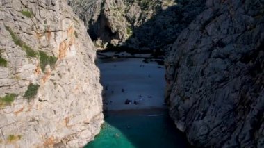 4K Hava Aracı 'nın eşsiz plaj videosu kanyona oyulmuş turkuaz mavi su ve demirli tekneler, Sa Calobra Plajı, Mallorca, İspanya