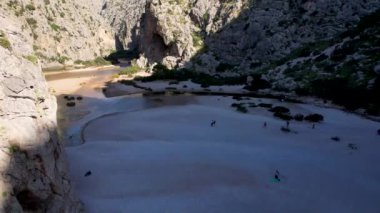 4K Hava Aracı 'nın eşsiz plaj videosu kanyona oyulmuş turkuaz mavi su ve demirli tekneler, Sa Calobra Plajı, Mallorca, İspanya