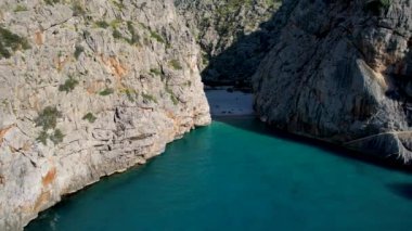 4K Hava Aracı 'nın eşsiz plaj videosu kanyona oyulmuş turkuaz mavi su ve demirli tekneler, Sa Calobra Plajı, Mallorca, İspanya
