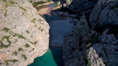 4K Hava Aracı 'nın eşsiz plaj videosu kanyona oyulmuş turkuaz mavi su ve demirli tekneler, Sa Calobra Plajı, Mallorca, İspanya