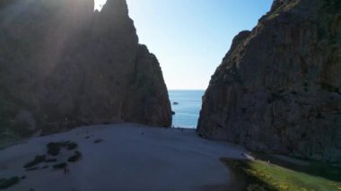 4K Hava Aracı 'nın eşsiz plaj videosu kanyona oyulmuş turkuaz mavi su ve demirli tekneler, Sa Calobra Plajı, Mallorca, İspanya