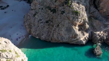 4K Hava Aracı 'nın eşsiz plaj videosu kanyona oyulmuş turkuaz mavi su ve demirli tekneler, Sa Calobra Plajı, Mallorca, İspanya