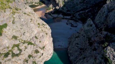 4K Hava Aracı 'nın eşsiz plaj videosu kanyona oyulmuş turkuaz mavi su ve demirli tekneler, Sa Calobra Plajı, Mallorca, İspanya